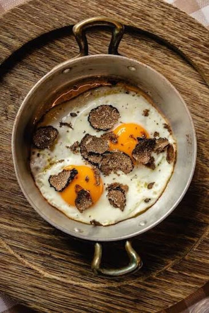 Eggs topped with shaved black truffles, showcasing the traditional flavors of Umbrian cuisine.
