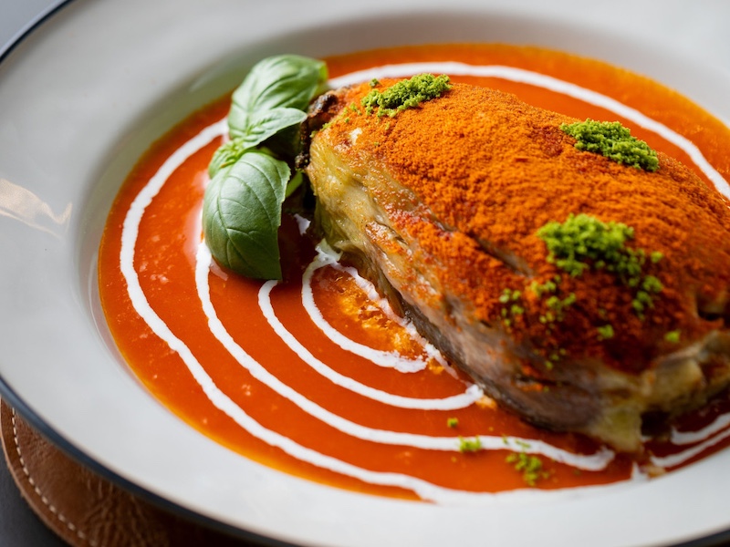 Gourmet Italian dish with colorful sauce and basil